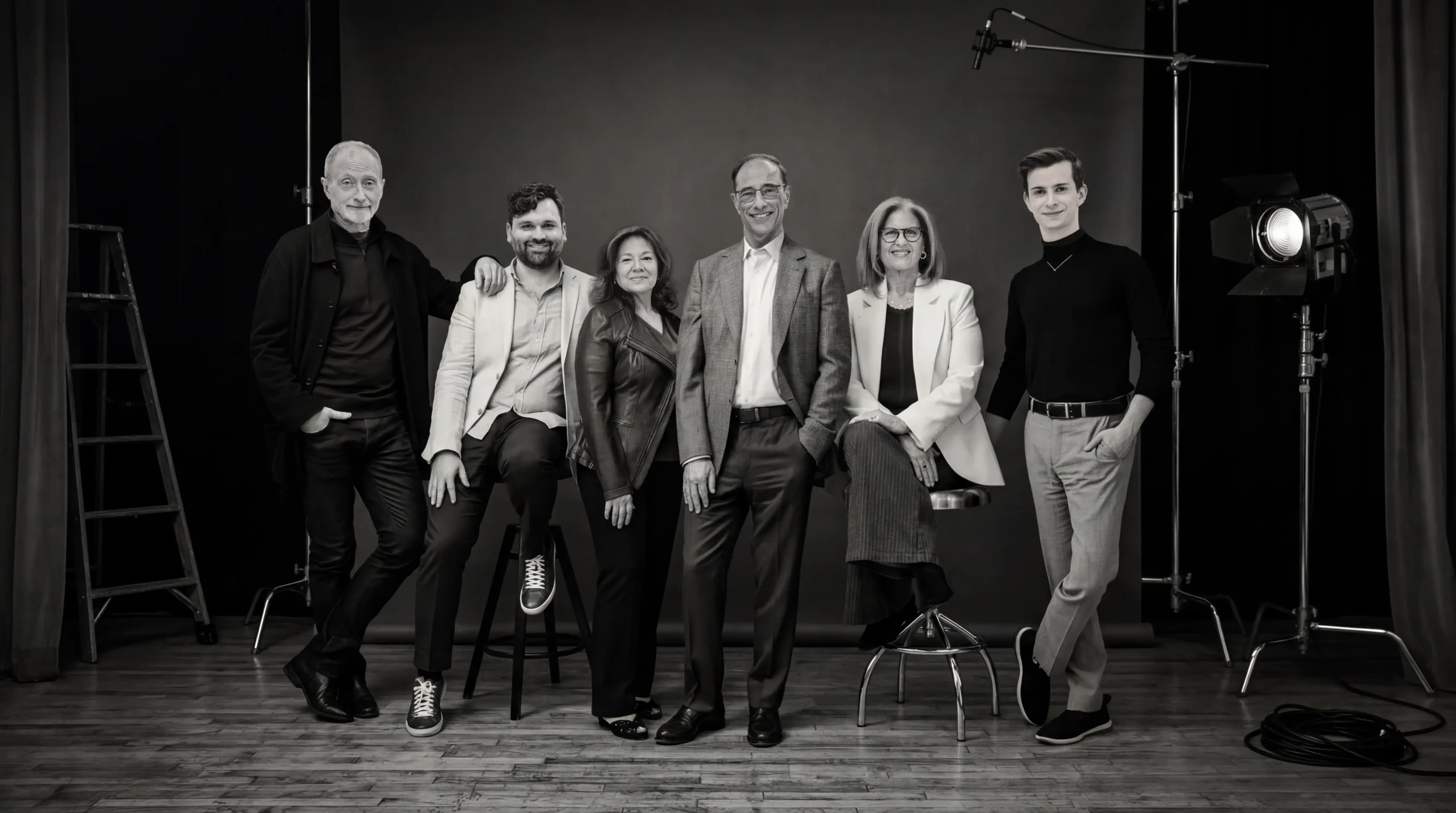 Black-and-white group photograph of the Halcyon Theatricals team in a studio. From left to right: Kelly Robinson, Kevin Connor, Ruth Pomerance, Hal Luftig, Cathy Dantchik, and Eli Cohen